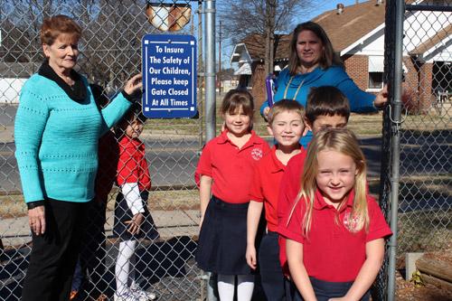 Principal Denise Troutman (left) and teacher Annette Sterl usher a group of first graders through the perimeter fence at North Little Rock Catholic Acad-emy. The school also regularly holds drills for intruders as well as for weather emergencies.