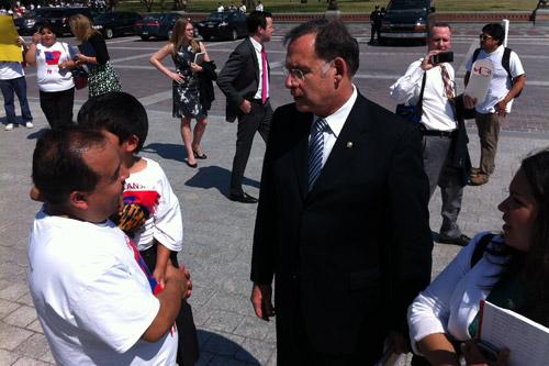 Arturo Reyes, business owner and father of six, holds his youngest son while speaking to Sen. John Boozman at the National Immigrant Advocacy Day Rally in Washington, D.C.