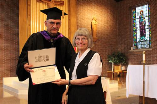 Sister Alice O'Brien of St. Scholastica Monastery in Fort Smith is congratulated by Dr. Ron Faulk of St. Gregory the Great University. Sister Alice earned a bachelor's degree in theology. Dwain Hebda photo