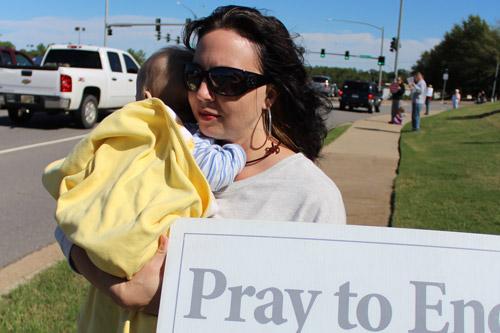 Suzanne Carter of St. Jude Church in Jacksonville shields 10-month-old Austin from the bright sunlight during the Life Chain. Dwain Hebda photo