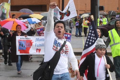 Nelson Escobar leads the walk across Walnut Avenue in Rogers Oct. 5 during a downtown march to support immigration reform. Gerard Davenport photo