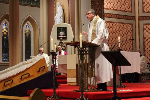 Father John Connell, pastor of St. Raphael Church in Springdale, delivers the homily at the vigil as Bishop Anthony B. Taylor looks on. Dwain Hebda photo