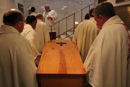 Pallbearer priests listen to a final blessing by Bishop Taylor prior to placing the coffin in the crypt. Dwain Hebda photo