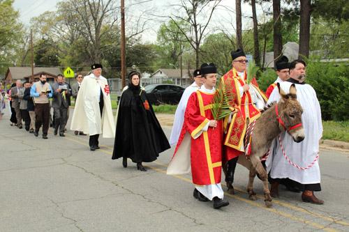 Father Michael Magiera, FSSP, rides a donkey at the head of a Palm Sunday procession by the St. John the Baptist Latin Mass Community en route to Mass at St. Patrick Church in North Little Rock. Arkansas Catholic photo by Dwain Hebda
