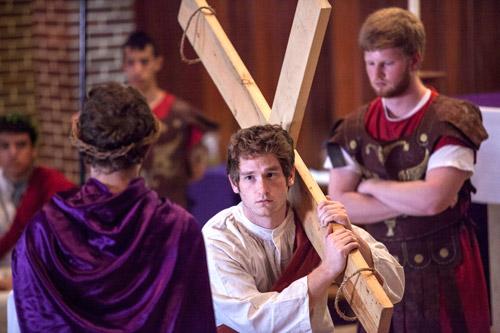 Simon (Andrew DeClerk) carries the cross for Jesus (Noah Findley) as a soldier (Reed Ptomay) watches during a live Stations of the Cross at St. Thomas Aquinas University Parish in Fayetteville April 14. Arkansas Catholic photo by Paul Dufford
