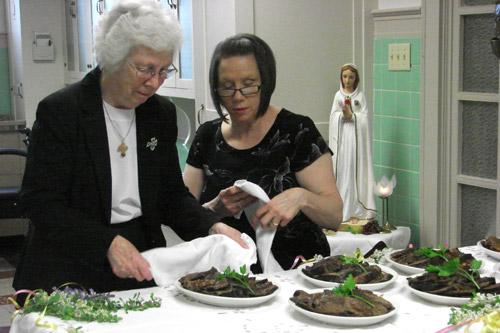 Prioress Sister Maria DeAngeli, OSB (left), and subprioress Sister Kimberly Prohaska, OSB, serve trays of meat to sisters and guests at St. Scholastica Monastery in Fort Smith on Holy Thursday before entering into silence for the Triduum. Arkansas Catholic photo by Maryanne Meyerriecks
