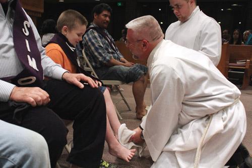 Father Mark Wood, pastor of St. Theresa Church in Little Rock, washes the feet of Andrew Gangluff on Holy Thursday. Arkansas Catholic photo by Dwain Hebda
