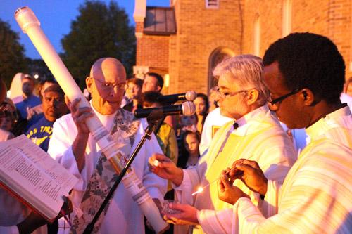 The Easter vigil at St. Joseph Church in Conway begins at dusk with lighting the Easter candle outside. Celebrating the Mass were pastor Father John Marconi and associate pastor Father Joseph Archibong.