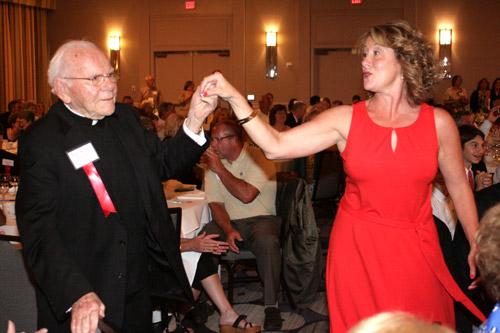 Msgr. Bernard Malone of Little Rock and Sonya Eisenhauer of Hot Springs Village couldn’t resist getting up and dancing to the seminarian band's version of the Beatles’ “Love Me Do”. Malea Hargett photo