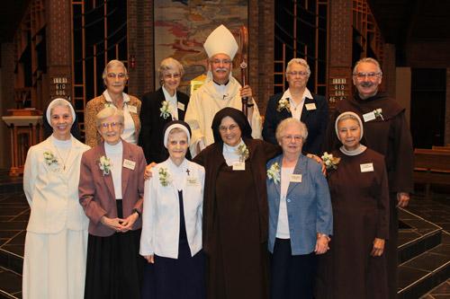 Bishop Anthony B. Taylor poses with jubilarians Sisters Madeline Bariola, OSB (back row, left); Stephanie Schroeder, OSB; Dorothea Moll, DC; Father John Michael Payne, OCD; and Sisters Marilyn Doss, OSB (front row, left); Rosalie Ruesewald, OSB; Mary Lucille Sluyter, RSM; Mary Petra Masek, OCD; Mary Chabanel Finnegan, RSM; and Cecilia Toledo, CMST. 