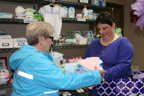 Melissa Ziegenhorn is known as the "Blanket Lady" at Arkansas Pregnancy Resource Center. She's seen here handing off blankets to center volunteer Joan Wehr. (Aprille Hanson)