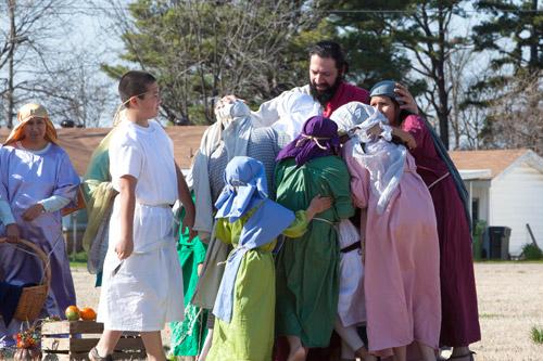 At St. Vincent de Paul Church in Rogers on Palm Sunday, Jesus, played by Rafael Pantoja, welcomes the children during a reenactment of Jesus coming into Jerusalem. (Paul Dufford)