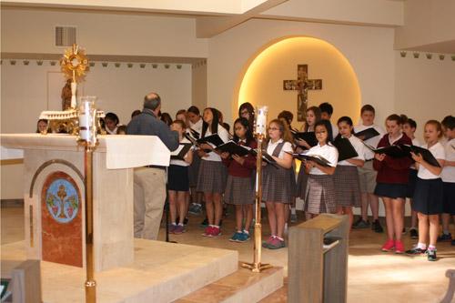 Christ the King choir students sing before Bishop Anthony B. Taylor blesses the chapel. The bishop led a procession to bless several new additions at the church and school. 