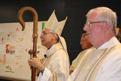 Bishop Taylor (left) and Msgr. Malone look on as the children said the Our Father in Spanish.