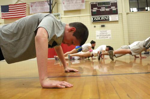 Seventh-grade fitness team member Dylan Moss pumps out a few more pushups before the clock runs out. Many participants balance fitness training with other sports.  (Dwain Hebda photo) 