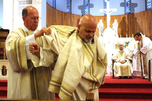 Deacon Noel “Bud” Bryant vests Norman McFall in the stole and dalmatic, indicative of his station as a Catholic deacon, during McFall’s ordination Mass May 20 in Pine Bluff. (Dwain Hebda photo) 