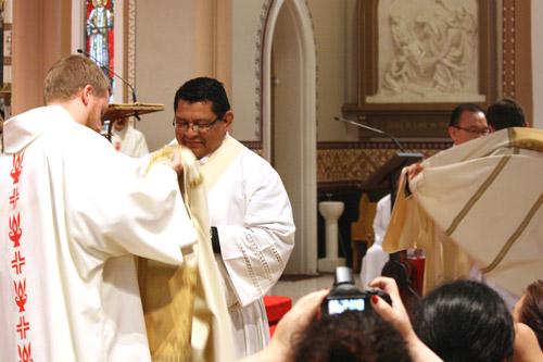 Deacon Kyle Rodden (left) of the Archdiocese of Indianapolis assists Mario Jacobo with his vestments while Deacon Joseph Chan assists Taryn Whittington with his stole and dalmatic. (Malea Hargett photo)