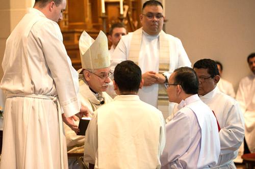 Joseph Chan kneels before Bishop Taylor during the ordination Mass. (Karen Schwartz photo)