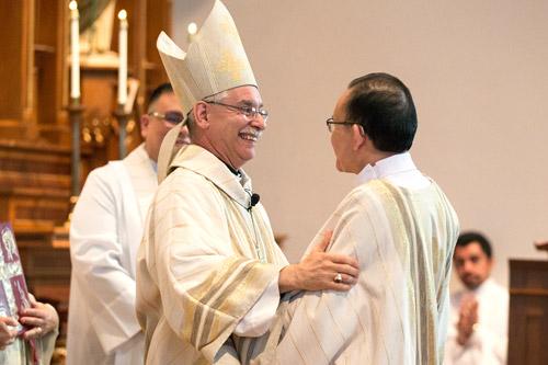 During the sign of peace Bishop Anthony B. Taylor embraces newly ordained Deacon Joseph Chan.  (Karen Schwartz photo)