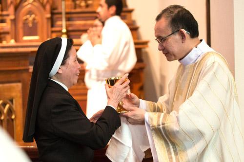 Deacon Joseph Chan distributes Communion to Sister Elizabeth Bui Thi-Nghia, RSM, of Springfield, Mo., during his diaconate ordination. (Karen Schwartz photo)