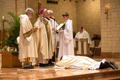 Brother Patrick Boland, OSB, lies prostrate before Bishop Anthony B. Taylor during the ordination rite June 20 at Subiaco. (Karen Schwartz photo)