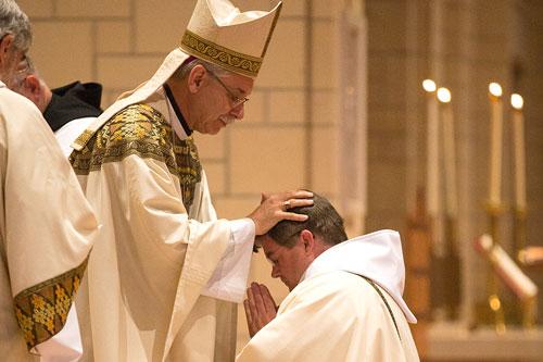 Bishop Anthony B. Taylor ordains Benedictine Patrick Boland to the priesthood by laying on of hands June 20 at St. Benedict Church at Subiaco Abbey. (Karen Schwartz photo)