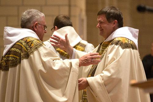 Abbot Leonard Wangler, OSB, abbot of Subiaco Abbey, moves to embrace newly-ordained Benedictine priest Father Patrick Boland during the sign of peace June 20. (Karen Schwartz photo)