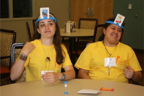Maddie Oxner, 18, a member of St. Joseph Church in Conway (left) and Rita Elizondo, 17, a member of St. Jude the Apostle Church in Jacksonville, play the game "HedBanz" with residents at Carelink.