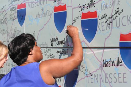 Bernadette Devone, of Pine Bluff, signs the bus outside the 12th Street Empowerment Center. Sister Simone said at each stop the bus makes, attendees are encouraged to sign it. 