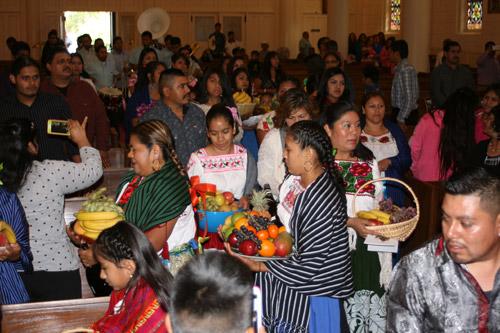 Women dressed in traditional Mexican dresses brought in fruit baskets. It is tradition to present the food to the priest celebrating the Mass as a thank you. (Aprille Hanson photo)