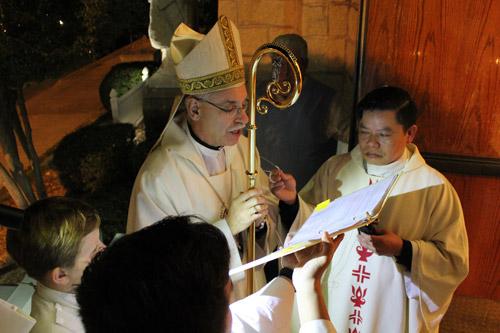 Bishop Anthony B. Taylor delivers a blessing to open the door of the Cathedral of St. Andrew in Little Rock, with help from  Cathedral rector Father Jack Vu, before Mass on the Feast of the Immaculate Conception, Dec. 8. (Dwain Hebda photo)