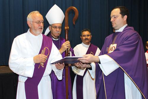 Bishop Anthony B. Taylor leads the Rite of the Opening of the Door of Mercy before Mass Dec. 13 at Our Lady of Good Counsel Church assisted by Deacon Kenny Stengel of Ratcliff (left), Deacon Marcelino Luna of Little Rock and pastor Father Josh Stengel. (Dwain Hebda photo)
