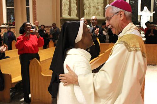 Bishop Taylor embraces Sister de Porres Polk, OSB, as he presents her with the 2016 Daniel Rudd Award. (Dwain Hebda photo)