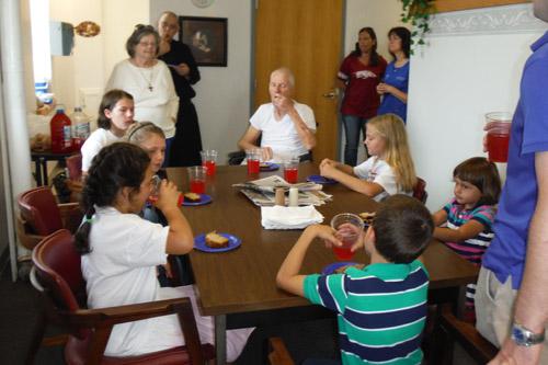 The Little Flowers Girls Club from St. Andrew Church in Ratcliff went to Subiaco Abbey’s infirmary, visiting with Sister Judith Weaver (back left), a diocesan hermit, Brother Andrew Suarez (back, standing) and the late Brother Eric Loran (seated, center).