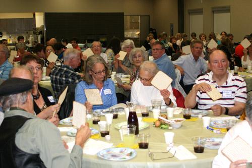 St. Mary of the Springs parishioners hold up their Matzo (unleavened bread) during the Seder meal March 10. (Aprille Hanson photo)
