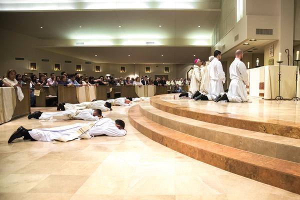 Five candidates for priesthood prostrate themselves in an act of surrender before God while the congregation sings the litany of the saints. (Bob Ocken photo)