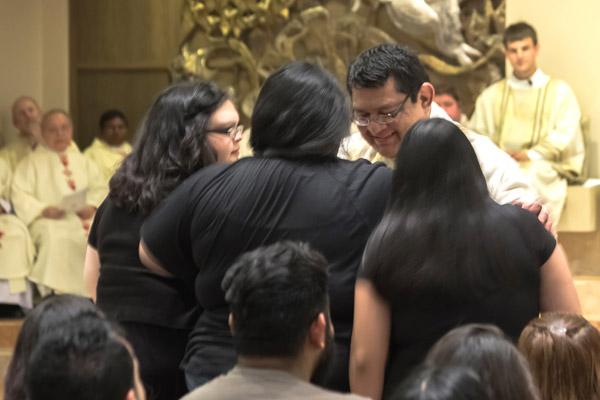 Newly ordained Father Mario Jacobo blesses members of his family from Georgia during the ordination Mass. (Bob Ocken photo)