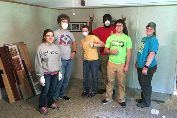 Students help lay flooring in the home of a low-income family in Appalachia during a May mission trip. Pictured are Holly Hambuchen (left), Sam Johnson, Clare Doss, Anthony Bassey, Blake Marshall and Morgan Burke. 