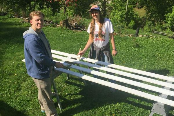 Students Nick Baltz and Katie Karp help paint a fence outside a home in Chavies, Ky. A $20,000 grant was given to the diocese by Catholic Home Missions to sponsor a mission trip for college students during the Year of Mercy.  