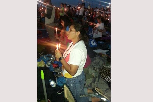 Brenda Martinez, 23, a parishioner at St. Edward Church in Little Rock prays at a youth vigil July 30. (Courtesy Rocio Montes)