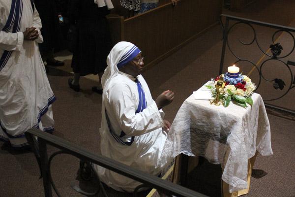 Sister Marie Jose kneels before St. Teresa's relics following Mass. St. Teresa had been canonized by Pope Francis the previous day. (Dwain Hebda photo)