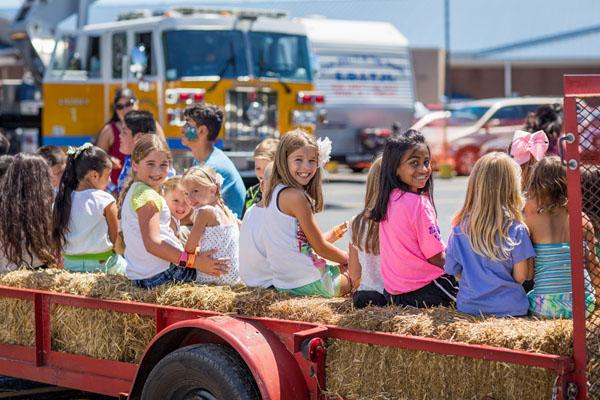 Bree McAfee, 10, Ava McAfee, 4, Ella McAfee, 4, Gabrielle Dickenson, 10, and Isabella Antony, 10, show happy faces as kids pile on for a hay ride around the church campus. (Travis McAfee photo) 