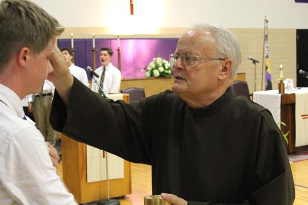 Brother Richard Sanker, CFP, administers a blessing to a student during Holy Communion. (Dwain Hebda photo)