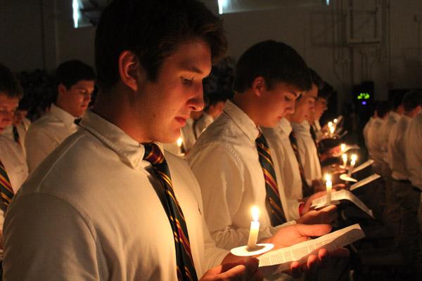 Seniors Russell Brown (left) and Griffin Woodall recite a prayer by candlelight during the 2016 Ring Mass, celebrated Sept. 14. (Dwain Hebda photo)