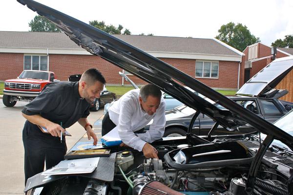 Father Stephen Gadberry and parish manager, Deacon Ronnie Hoyt, examine the engine of a "Smoky and the Bandit" Trans Am, at the annual St. Vincent de Paul parish festival Sunday, Sept. 24. The car show is held in conjunction with the festival every year. (Alesia Schaefer photo)
