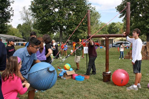 Leila Collyge, a third-grader at St. Vincent de Paul School, launches a giant ball in a slingshot with the help of Louis Silva, a ninth-grader at the New Technology School in Rogers. The "Angry Birds" game was one of several field games festival-goers could participate in at the church's annual festival Sept. 24. (Alesia Schaefer photo)