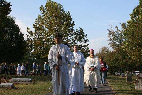 Seminarian Omar Galván carries the cross during the rosary procession at Calvary Cemetery Nov. 2. (Aprille Hanson photo)