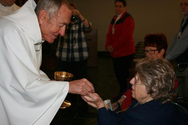 Longtime friend Father Mark Stengel, OSB, pastor of St. Benedict Church in Subiaco, gives Sister Margaret communion. He was to be the celebrant at her funeral Mass Jan. 13. (Aprille Hanson photo)