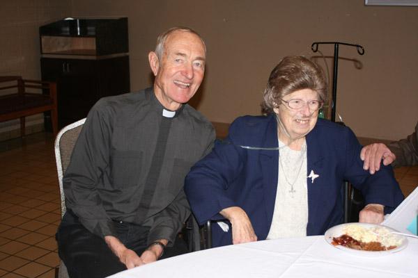 Father Mark Stengel smiles with Sister Margaret at her Jan. 4 retirement reception. He has known her since 1985, when they were both serving the Church in Belize. (Aprille Hanson photo)
