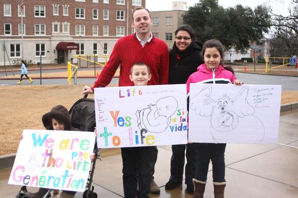 Adam and Marcela Stengel and their three children, members of St. Anthony Church in Ratcliff, display their homemade signs for the March for Life in Little Rock. (Malea Hargett photo)